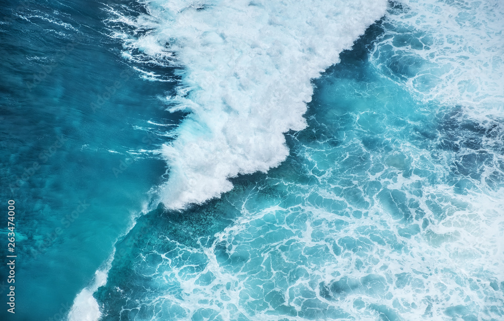 Waves and azure water as a background. View from high rock at the ocean surface. Natural summer seas