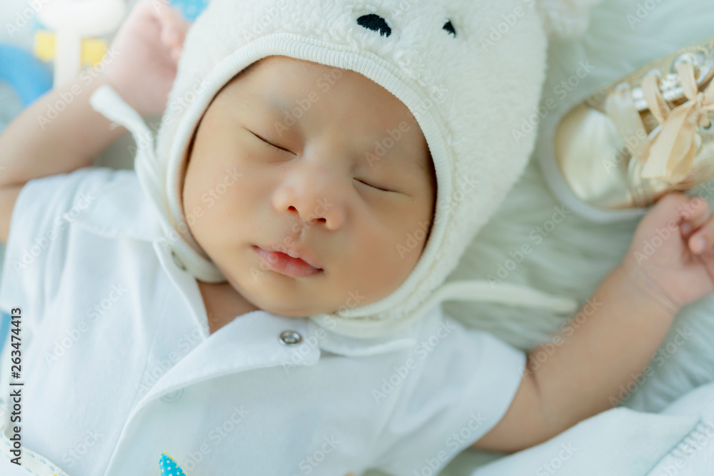 cute infant baby boy sleep with sweet dream and peaceful white soft bed