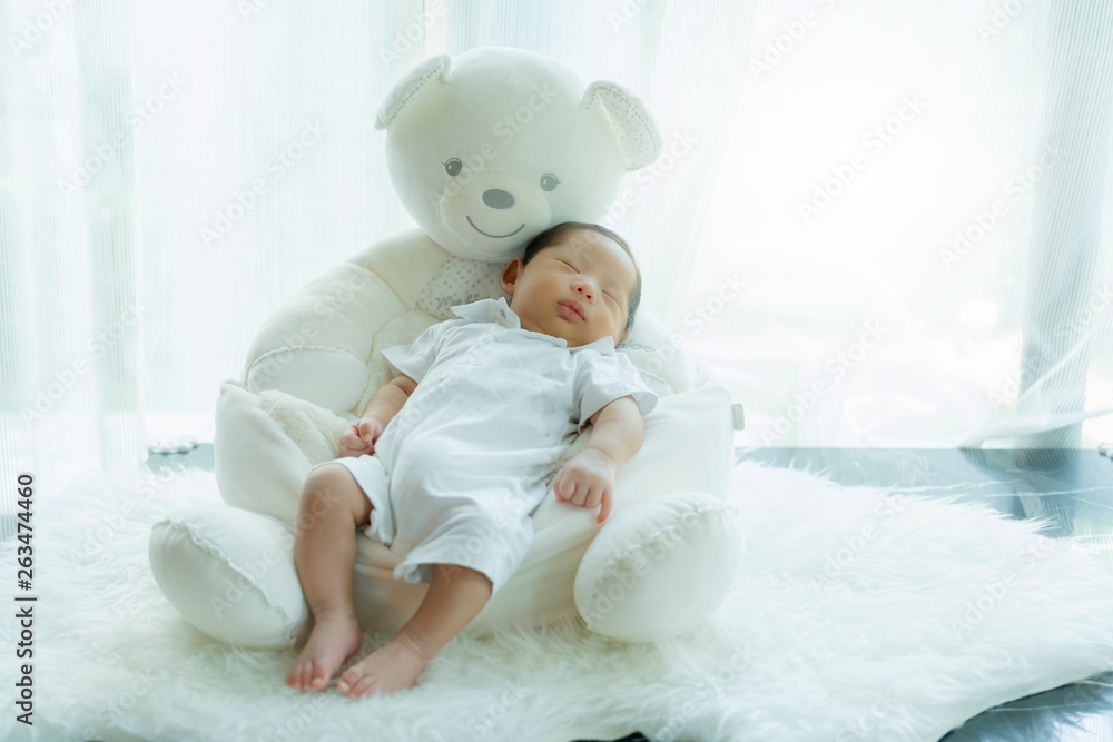 cute infant baby boy sleep with sweet dream and peaceful white soft bed