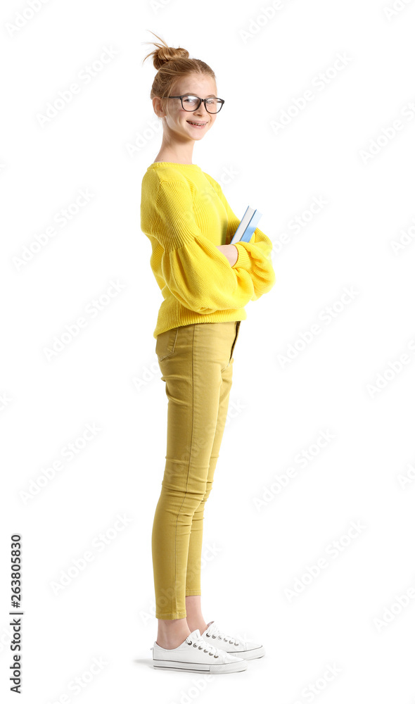 Portrait of cute teenage girl with book on white background