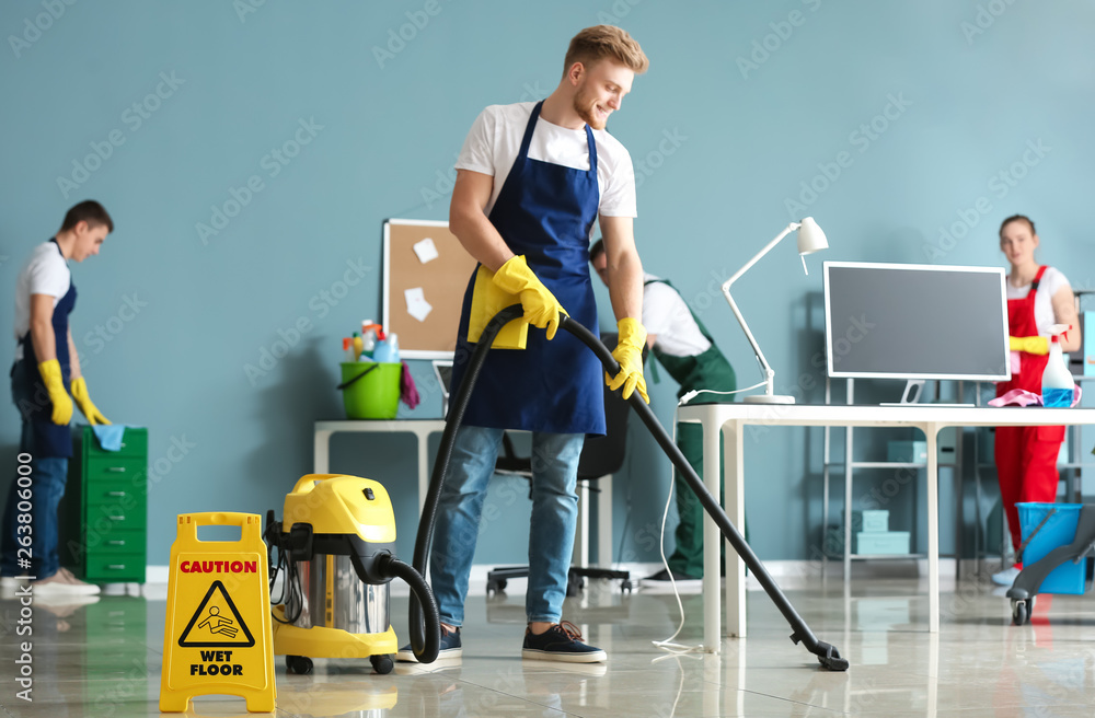 Team of janitors cleaning office