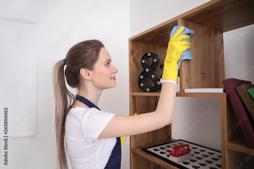 Female janitor cleaning rack in room