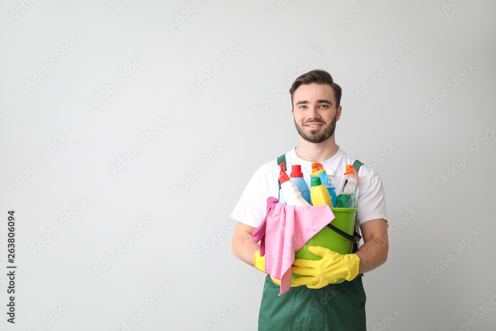 浅色背景下带清洁用品的男性看门人肖像