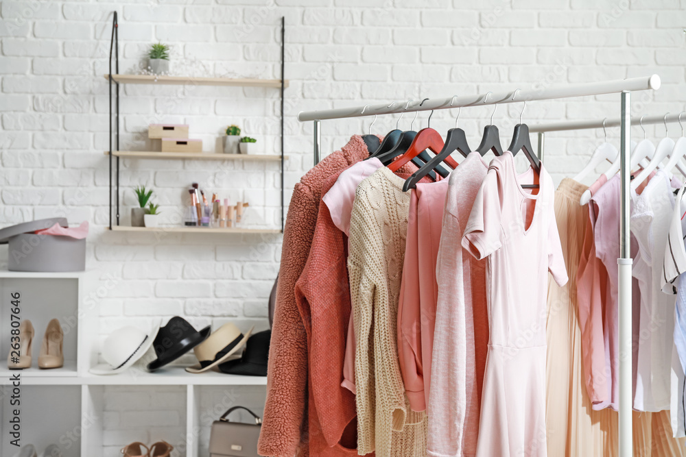 Rack with stylish clothes in dressing room