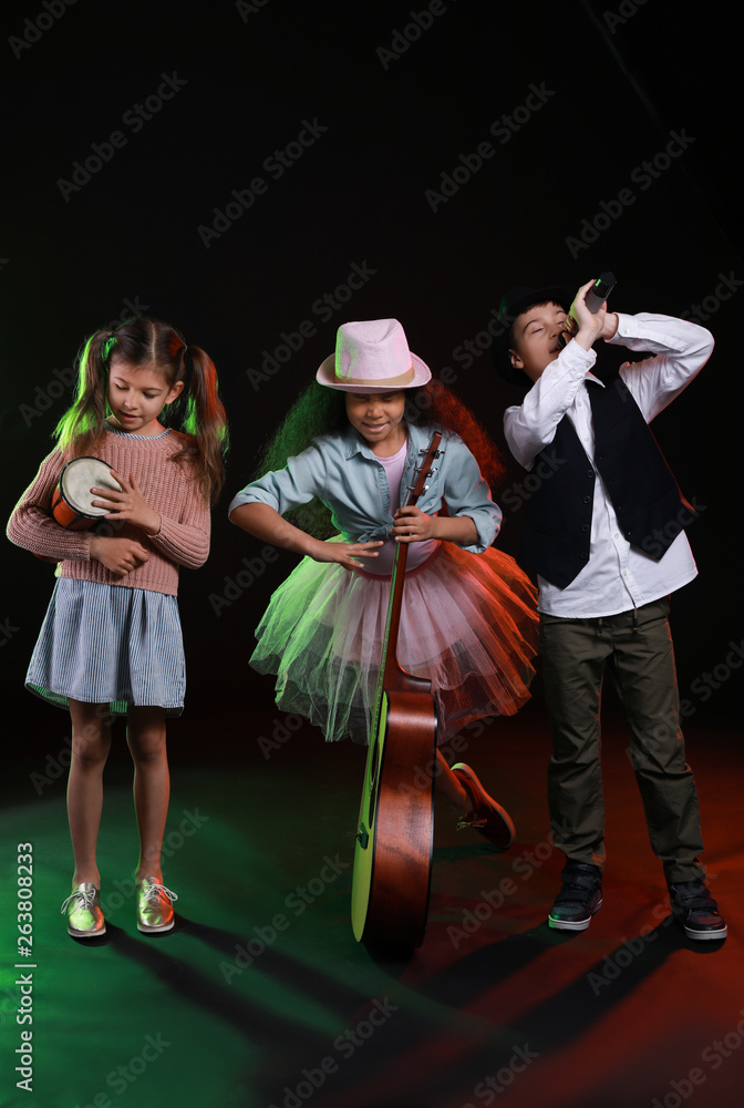 Band of little musicians on dark background