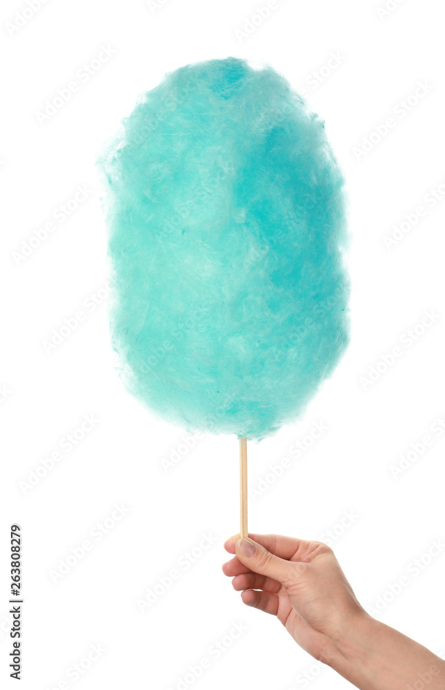 Female hand with tasty cotton candy on white background