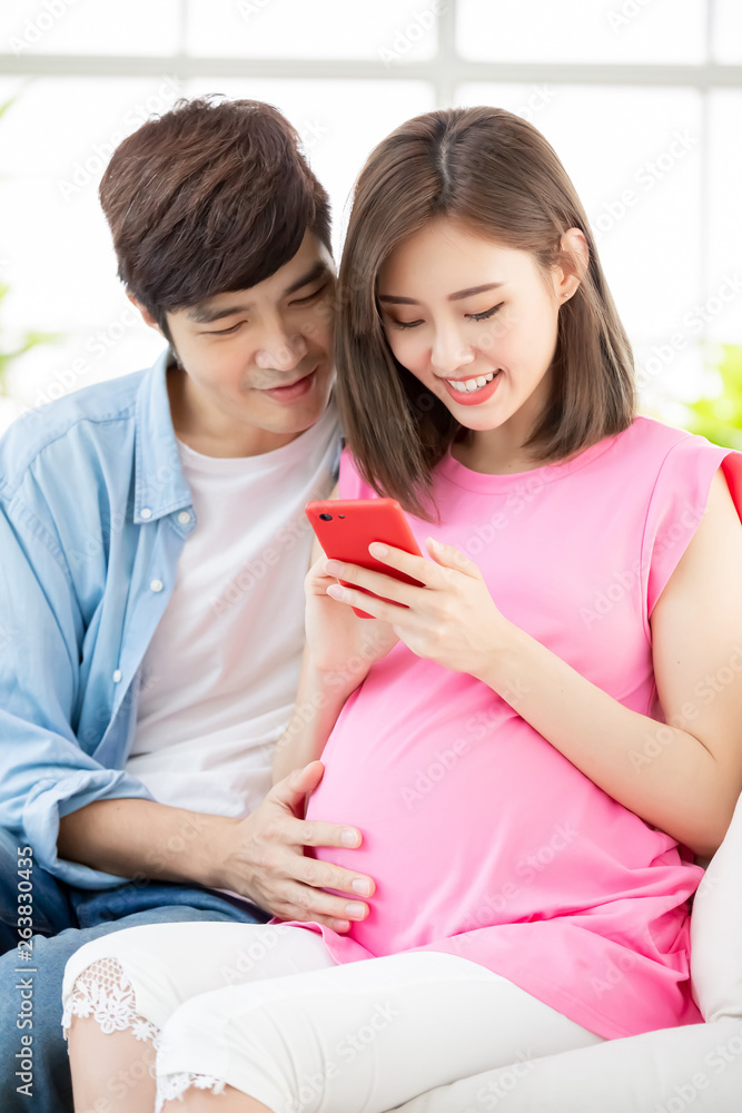 Pregnant couple use smart phone