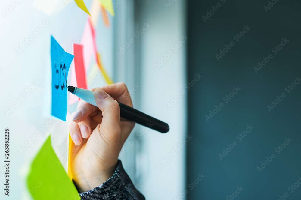 Businesswoman writing on colorful sticky note paper