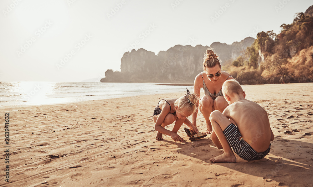 Mom and her children playing together on a sandy beach