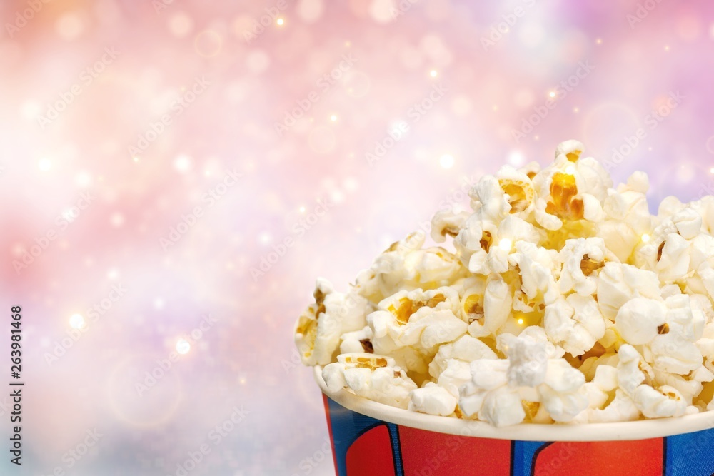 Bucket with popcorn on blurred background