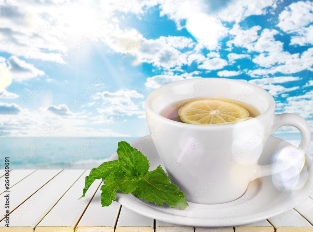 Tea with sliced lemon on background