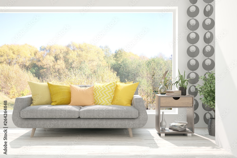 Stylish room in white color with sofa and autumn landscape in window. Scandinavian interior design. 