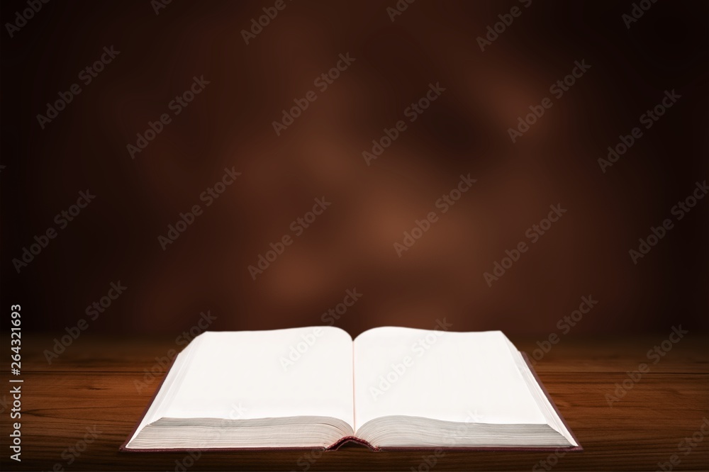 Open book on old wooden table.