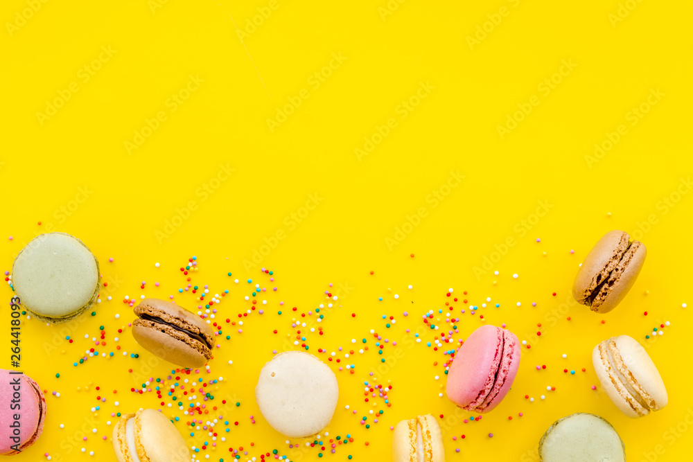 Macarons dessert pattern on yellow background top view copy space