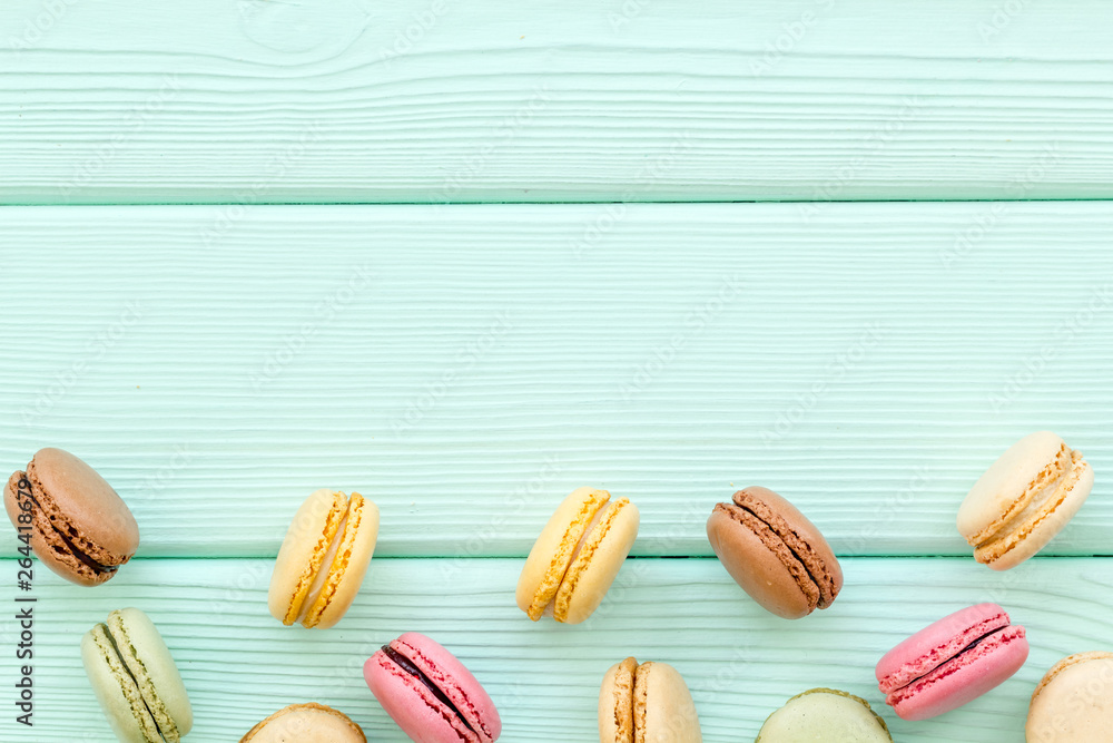 sweet dessert pattern with macarons on mint green wooden background flat lay mockup