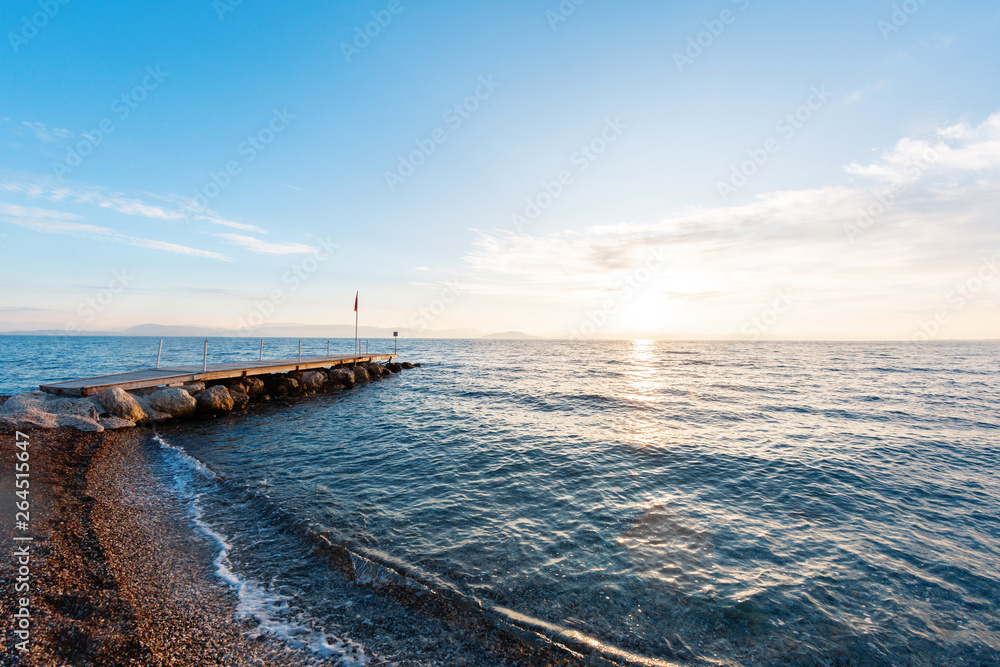 Summer sunrise on coast, Corfu island, Greece. Beach with perfect views of the mainland Greece mount