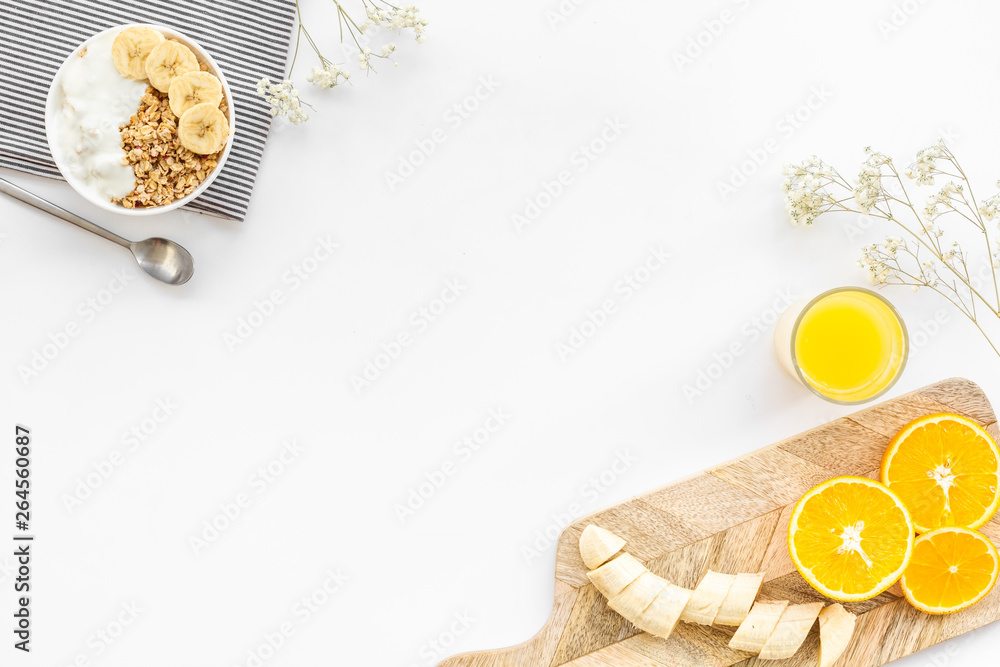 granola with banana slices and orange juice for breakfast on blue background top view copyspace