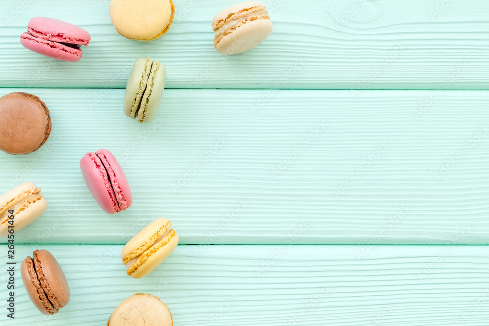 Macarons dessert pattern on mint green background top view copy space