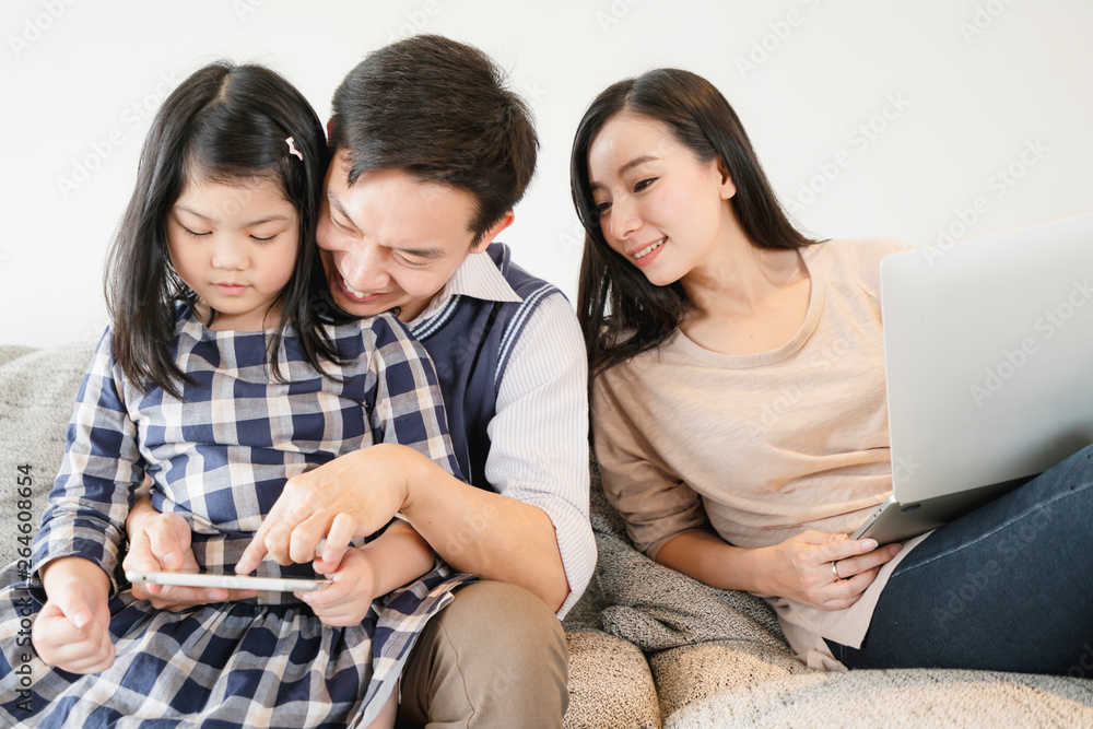 happiness asian family weekend vacation with mom dad daughter stay together use tablet and laptop ho