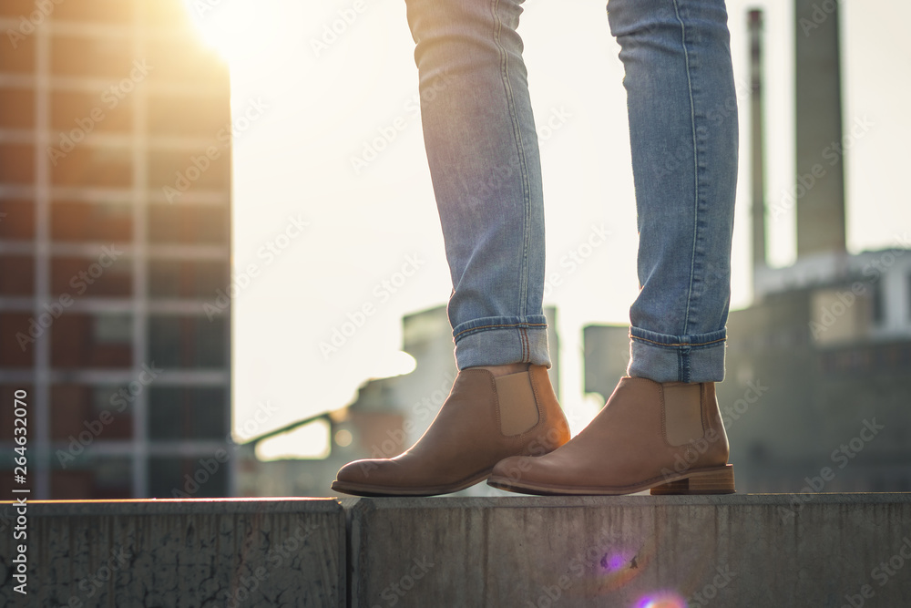 穿着休闲服的女人站在城市里。穿着牛仔牛仔裤和皮鞋的女人腿