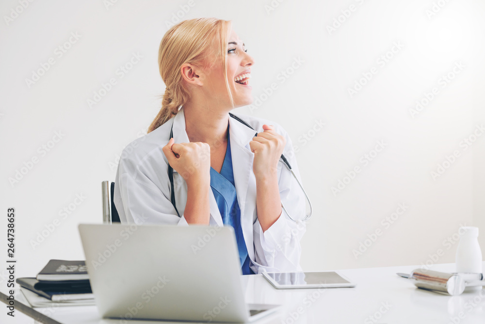 Happy successful woman doctor feels delightful in hospital or healthcare institute while working on 