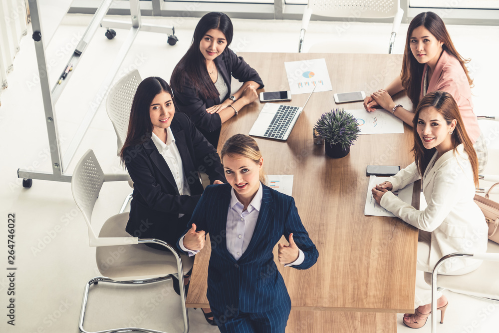 Businesswoman in group meeting discussion with other businesswomen colleagues in modern workplace of