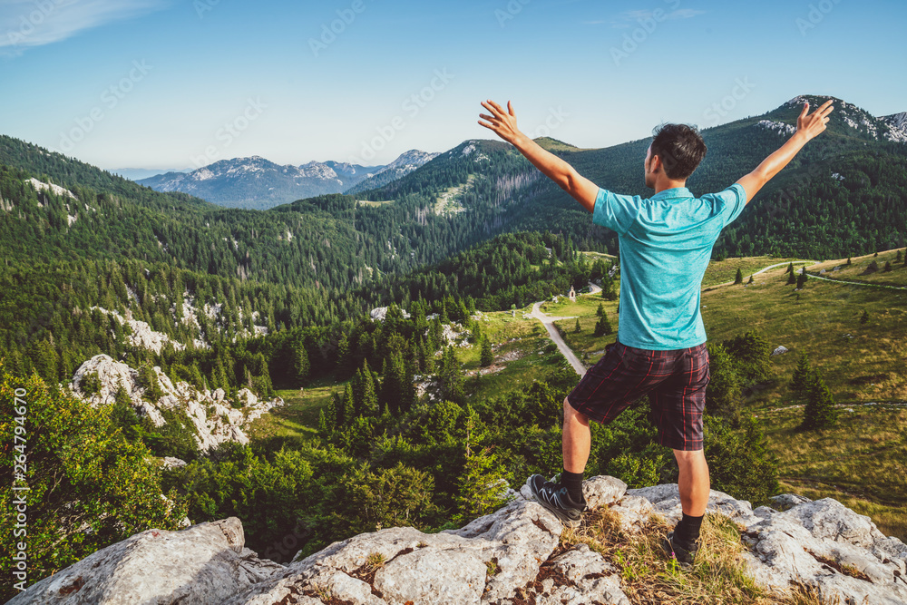 Young man traveler and explorer travels in the forest and mountain nature landscape hiking across Za