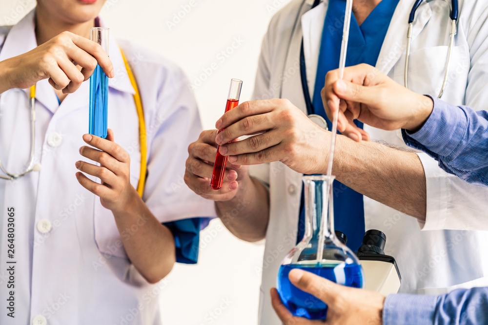 Group of scientists wearing lab coat working in laboratory while examining biochemistry sample in te