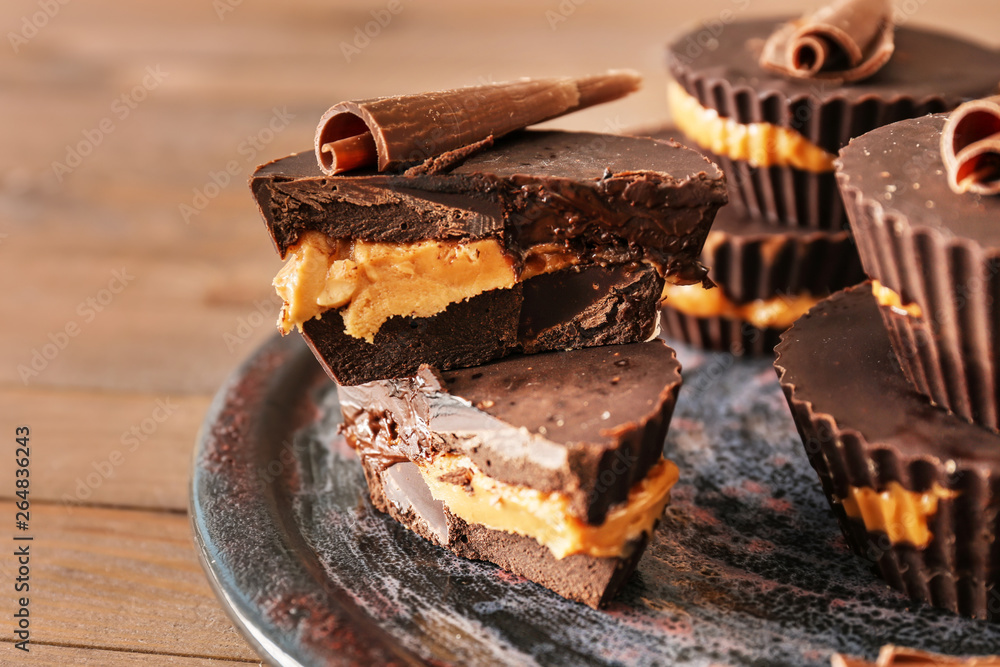 Tasty chocolate peanut butter cups on plate, closeup