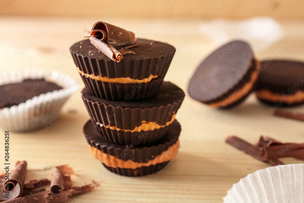 Tasty chocolate peanut butter cups on wooden table