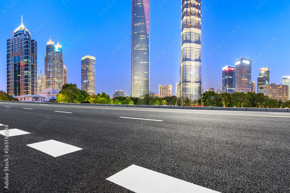 Shanghai modern commercial office buildings and empty asphalt road at night,panoramic view