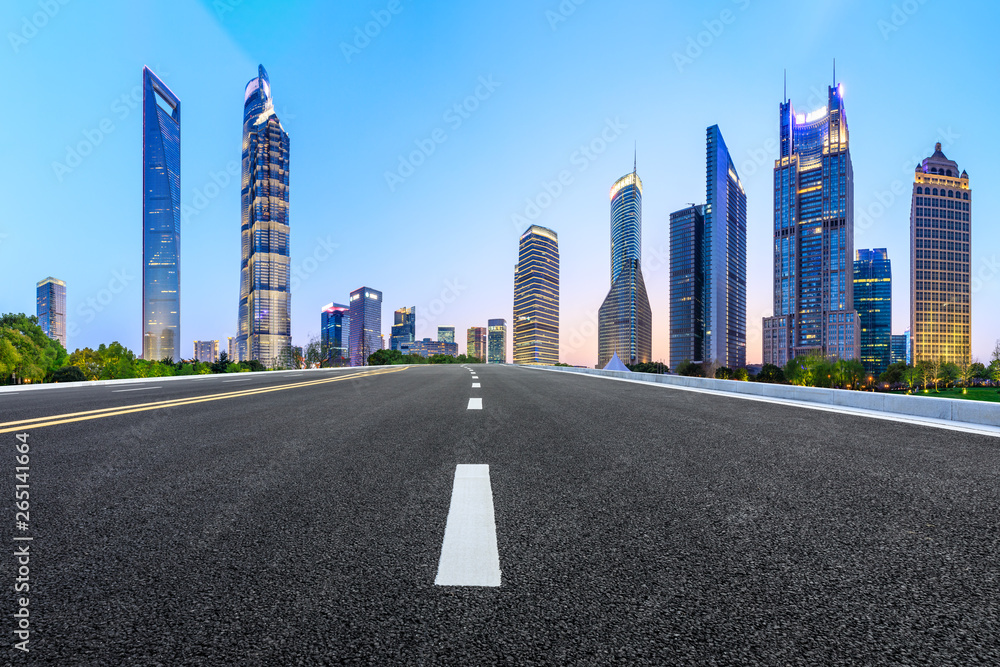 Shanghai modern commercial office buildings and empty asphalt road at night,panoramic view