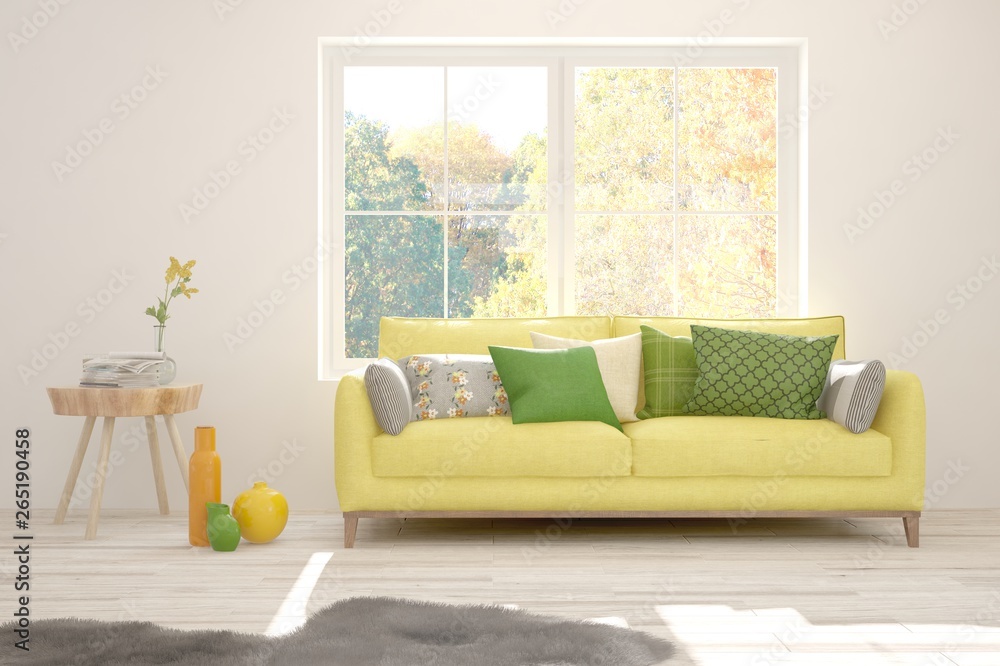 Stylish room in white color with sofa and autumn landscape in window. Scandinavian interior design. 