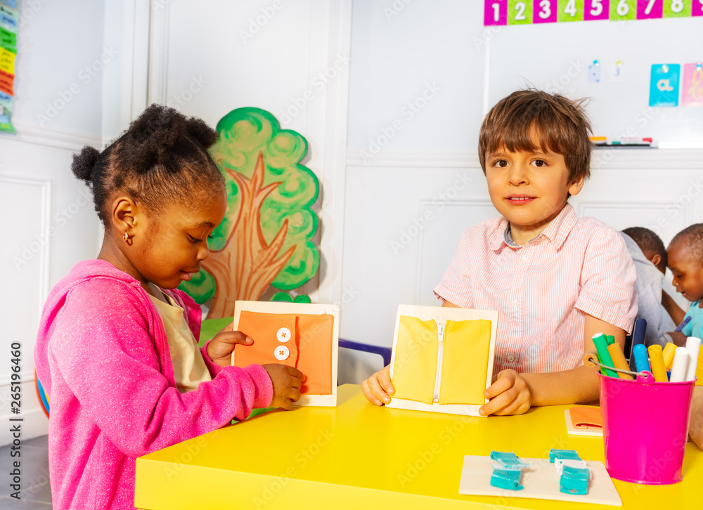 Boy with girl in nursery button and zip clothes