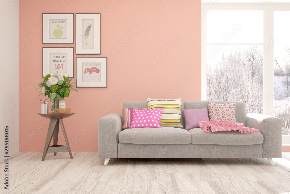 Stylish room in coral color with sofa and winter landscape in window. Scandinavian interior design. 