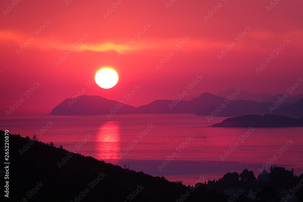 DRONE: Breathtaking shot of sun setting behind islands and calm sea in Dalmatia.