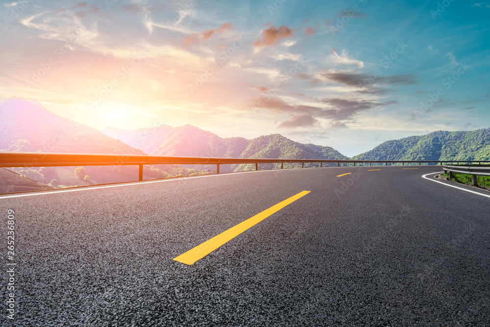 Asphalt highway and beautiful natural landscape at sunset