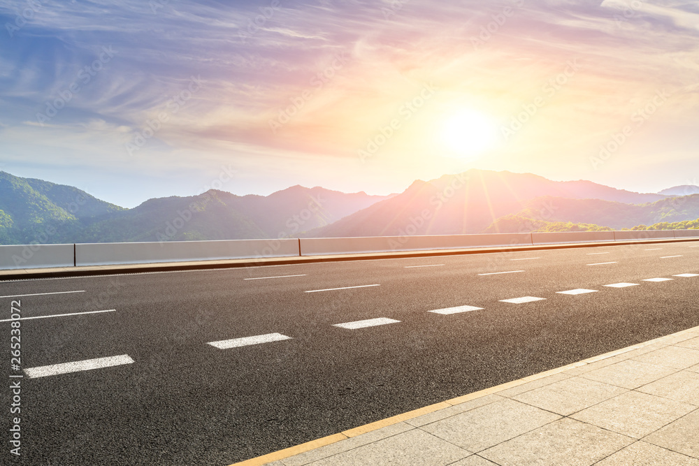 Asphalt highway and beautiful natural landscape at sunset