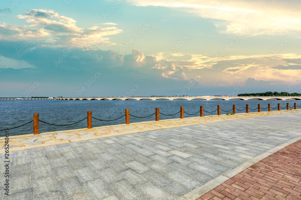 Beautiful lake and walkway with sky clouds at sunset