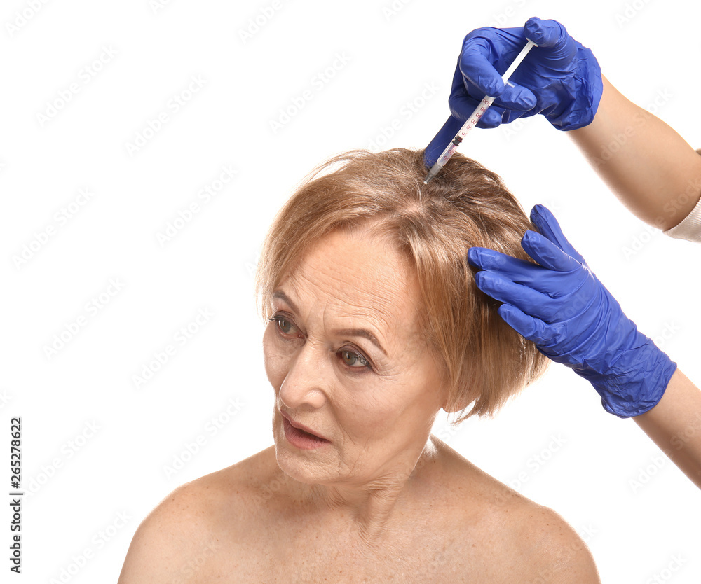 Beautiful mature woman receiving injection against white background