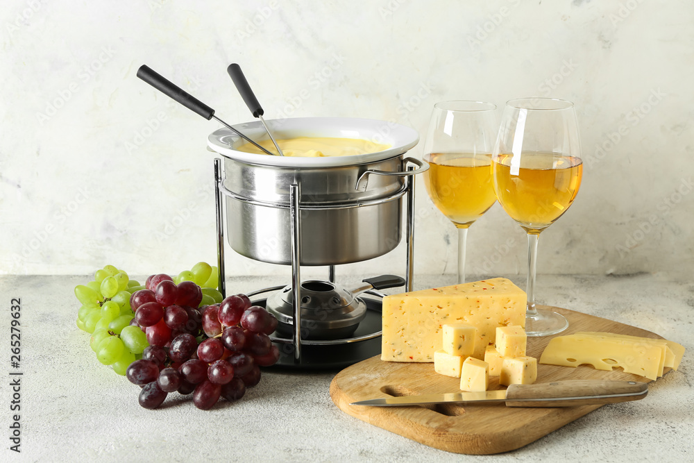 Cheese fondue with glasses of wine on table