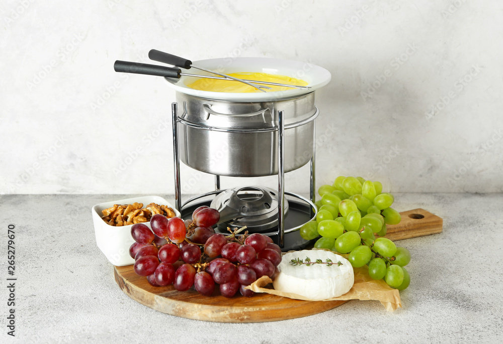 Cheese fondue with snacks on table