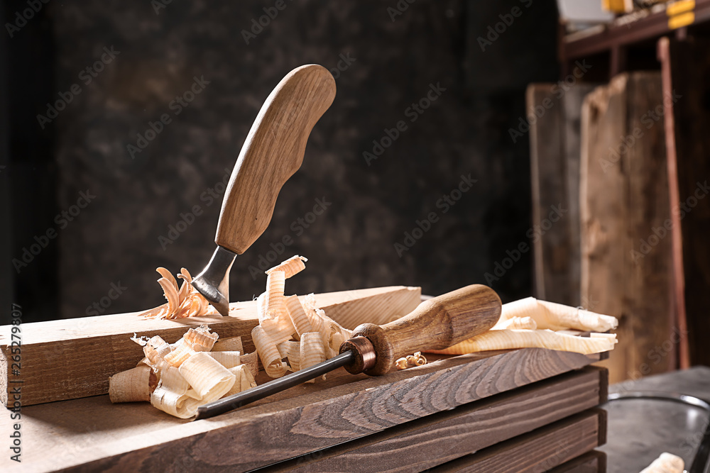 Carpenters chisels on wooden box in workshop