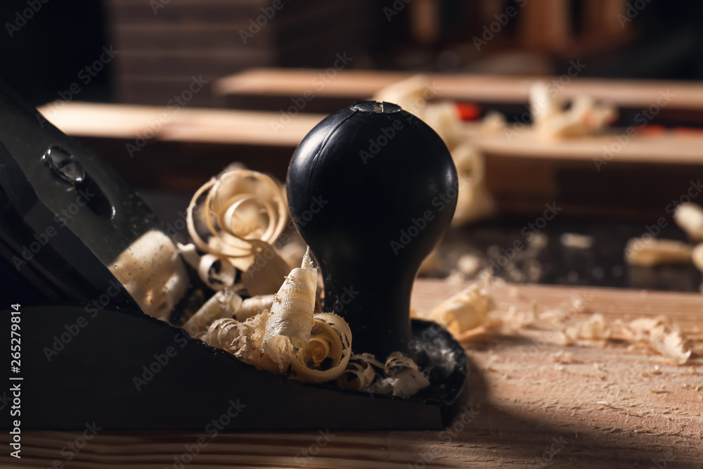 Carpenters smoothing plane on wooden plank, closeup