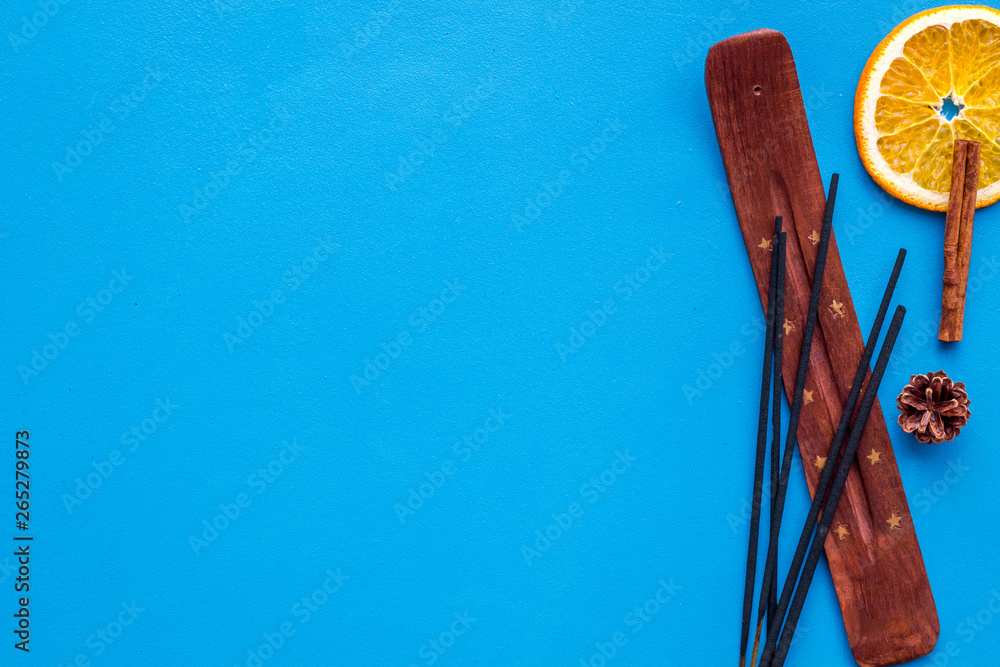 air freshener sticks with cinnamon and orange on blue background top view mockup