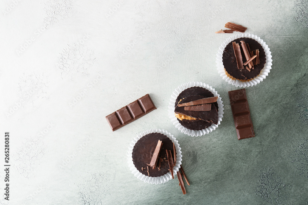 Tasty chocolate peanut butter cups on color background