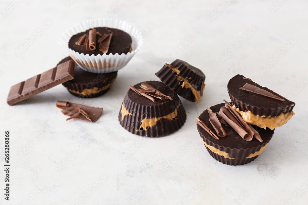 Tasty chocolate peanut butter cups on light background