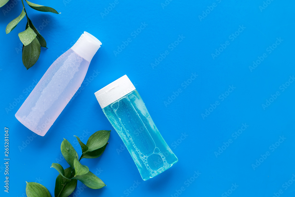 skin care cosmetics with facial tonic, mycelial water and plant on blue background top view mockup