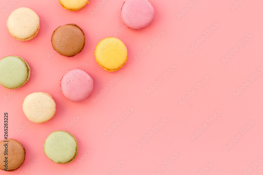 Brignt macarons for sweet break on pink background top view mock up