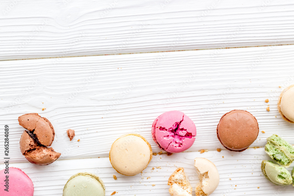 Macarons design on white wooden background top view space for text